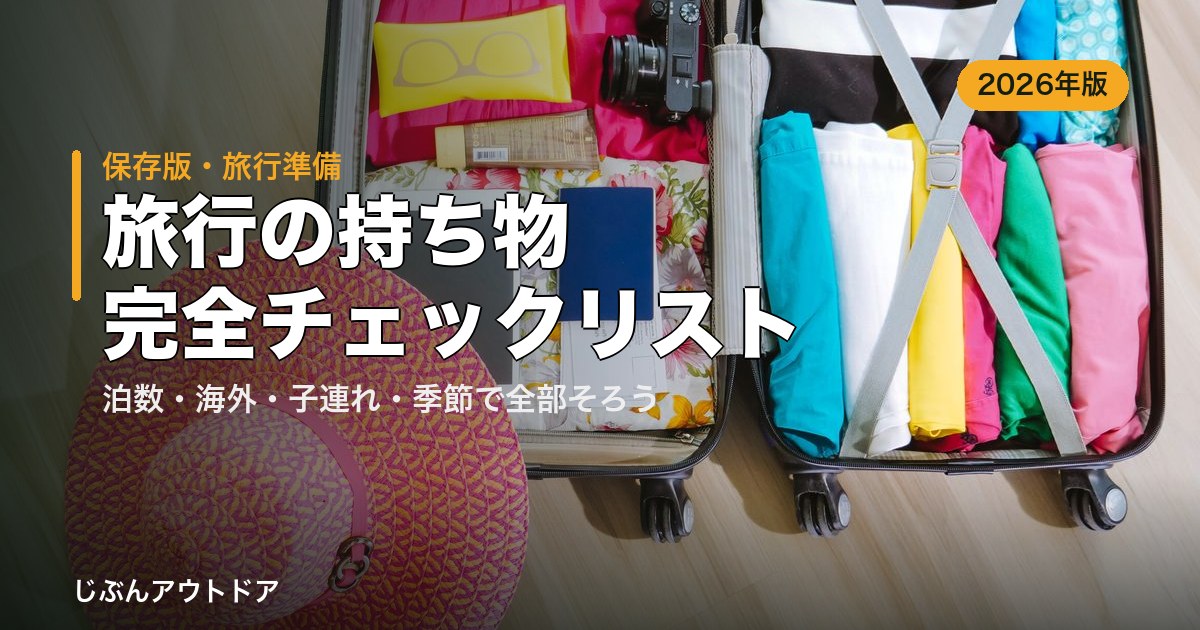 開いたスーツケースに服やカメラ・帽子を詰めた旅行の準備