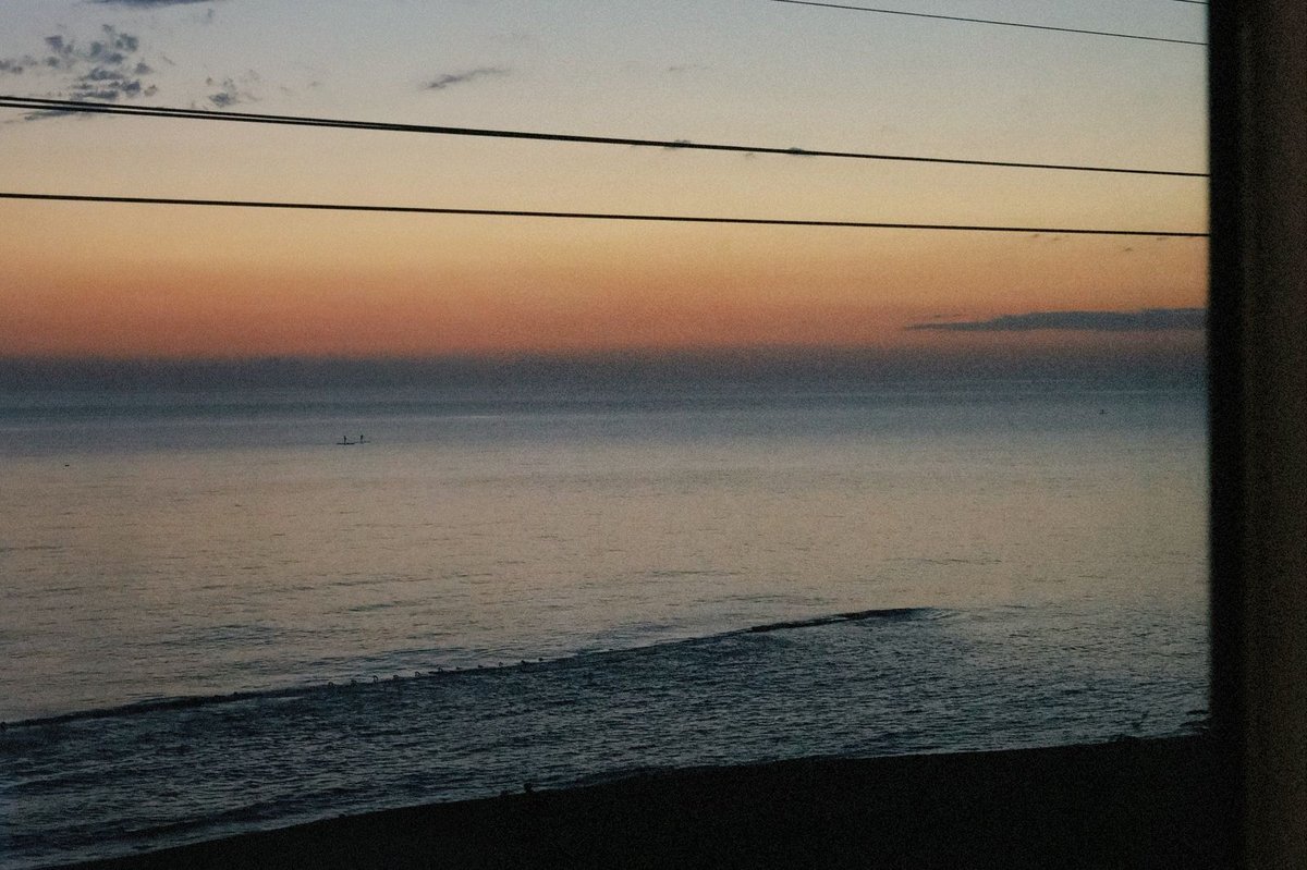 列車の車窓から見える夕暮れの海